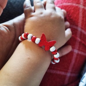 Bratara copii elastica, cu charm fluturas rosu stilizat si margelute din lemn, model 14